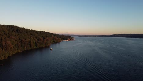 Vista-Aérea-De-Paseos-En-Bote-Por-El-Lago-Washington-Al-Atardecer-Con-El-Monte-Rainier-Al-Fondo