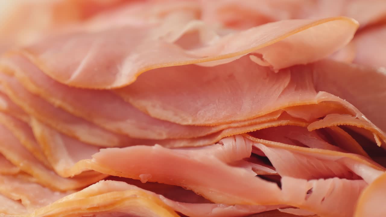 Ham italian mordatella, man Slices Of Traditional Italian antipasti mortadella sausage on a wooden cutting board, close up macro of chicken or turkey jamon, fat breakfast dish.