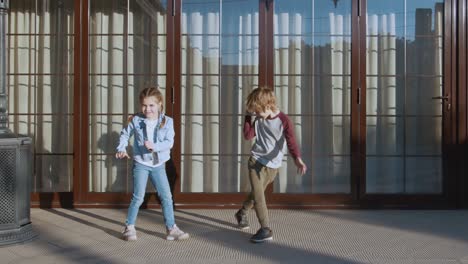 smiling dancing small girl and boy outdoors