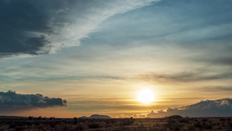 The-sun-sets-over-the-colorful-Mojave-Desert's-rugged-terrain---long-duration-fast-moving-time-lapse