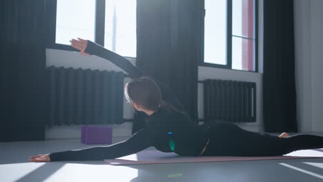 mujer practicando yoga en un estudio