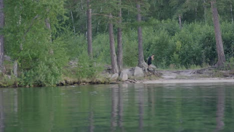 man hiking along a forest trail near a lake