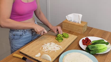 woman preparing a healthy meal with avocado and vegetables