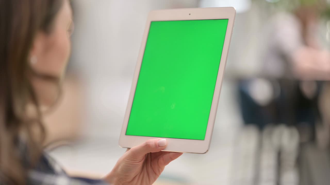 mujer usando tableta con pantalla de tecla de croma verde