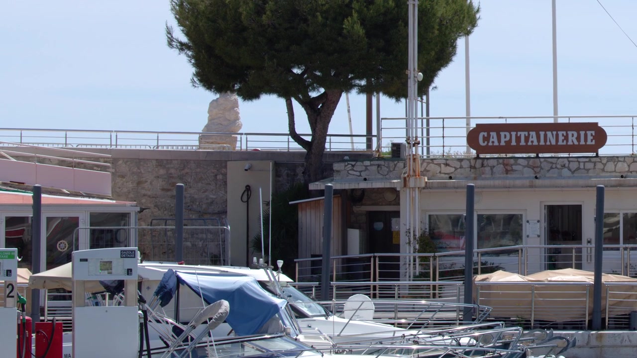 Bandiera dell'Unione Europea sventola sopra l'ufficio del capitano del porto e il porto turistico a Cassis, Francia.