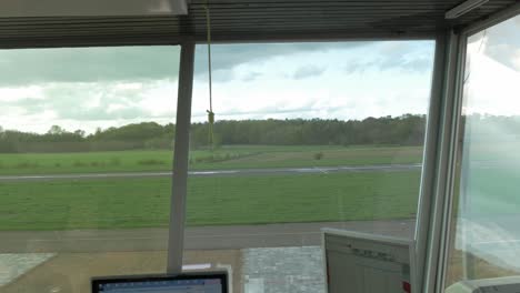 Interior-of-airport-tower-with-control-computers-and-view-to-airstrip