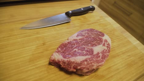 marbled a4 wagyu beef on wooden cutting board with sharp knife