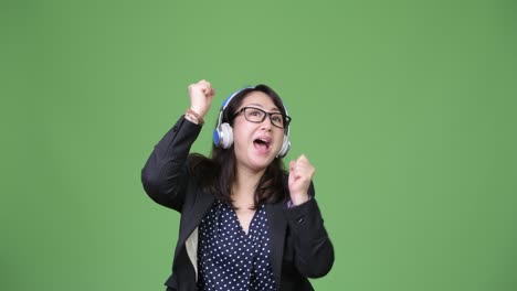 mature beautiful asian businesswoman listening to music
