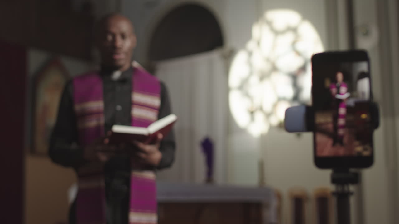 African-American Priest Recording Sermon on Smartphone Camera