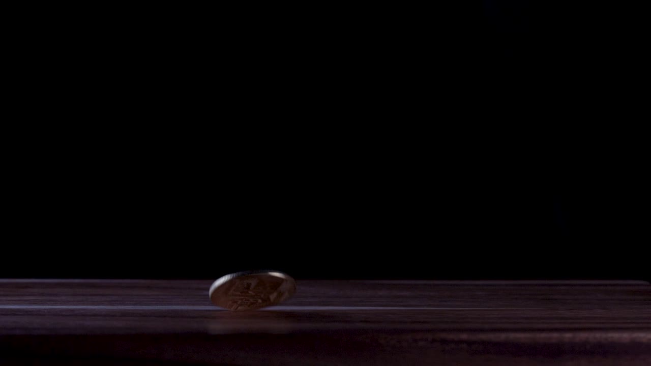 bucle ininterrumpido de una criptomoneda bitcoin girando sobre una superficie oscura con fondo oscuro