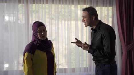 Muslim-couple-arguing-at-home,-husband-and-wife-yelling-at-each-other.