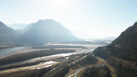 Amplia-Toma-Aérea-Del-Río-Fraser-En-La-Parte-Baja-Del-Continente-En-Columbia-Británica-En-Canadá,-Escena-Brillante-Con-Montañas-Nubladas-En-Otoño