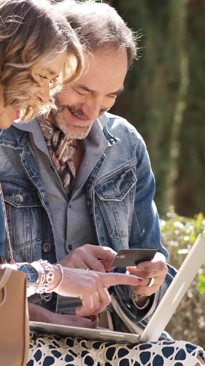 Man reading data from plastic card while woman entering it into netbook. Vertical footage