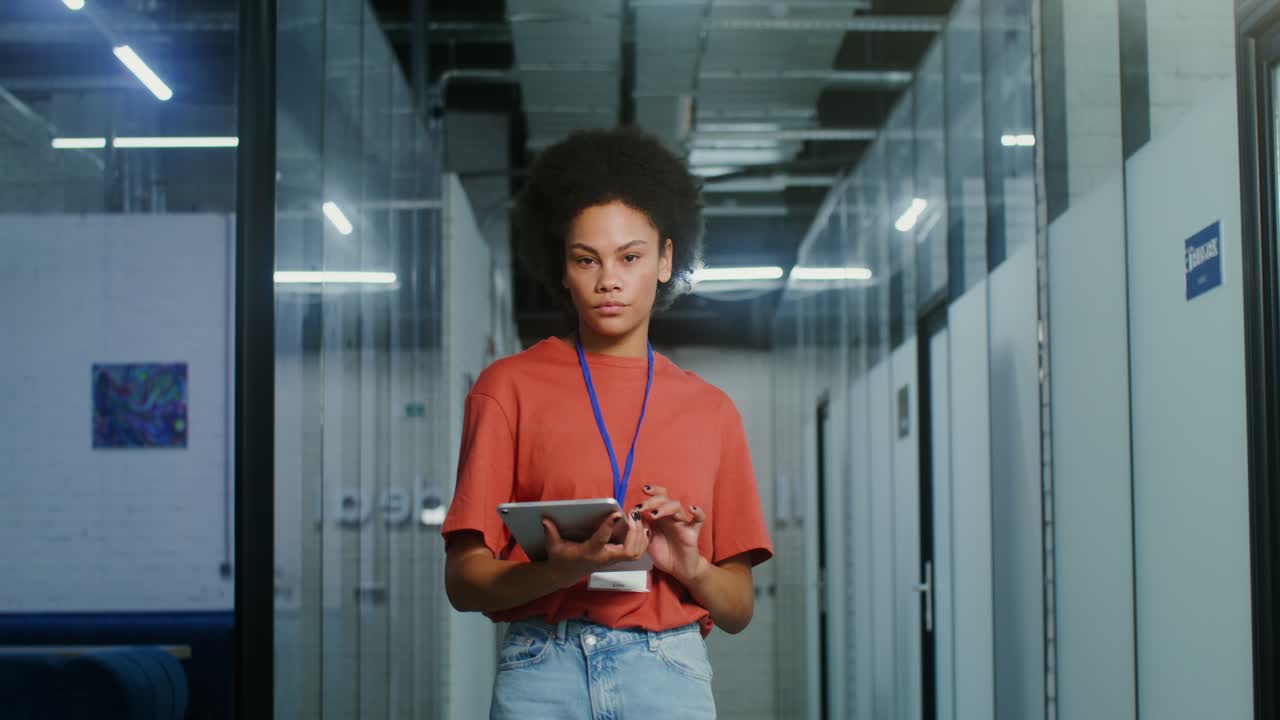 Young Woman Working on Tablet in Office Corridor