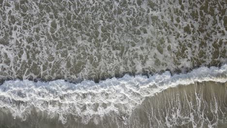 Atemberaubender-Blick-Von-Oben-Auf-Die-Wellen,-Die-Auf-Einen-Strand-Rollen