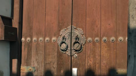 traditional korean hanok door handle, representing historical craftsmanship and cultural heritage, intricate metalwork and rich wooden texture, close-up parallax shot