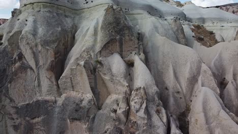 Drone-moving-from-the-right-to-the-left-side-of-the-frame-around-the-natural-rock-formations-of-Cappadocia,-located-in-Central-Anatolia-in-Turkey