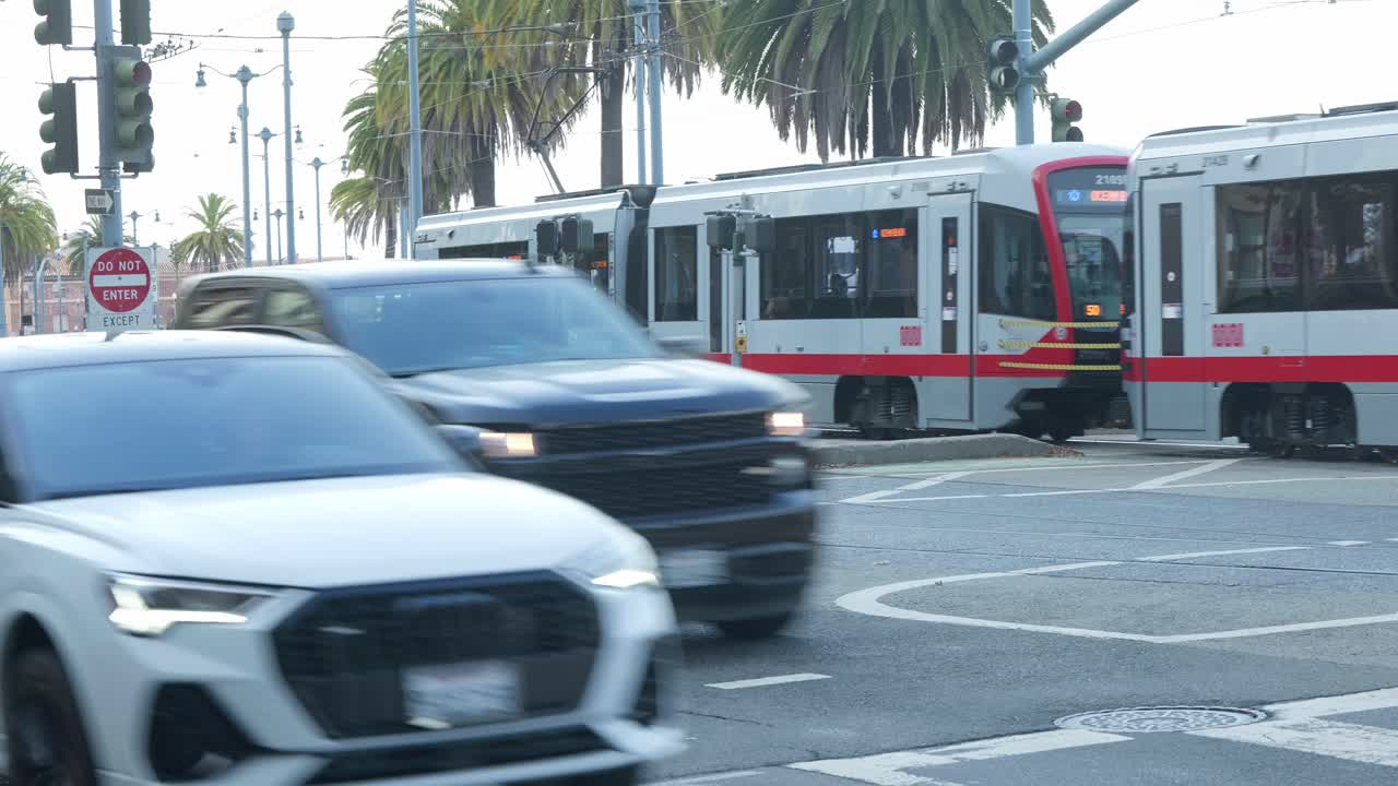 A Muni Transit Train glides smoothly into a tunnel along the Embarcadero, its sleek cars illuminated by city lights. The vibrant energy of downtown San Francisco as the train disappears underground.