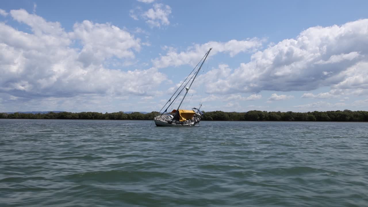 un velero se mueve constantemente a través de un lago sereno