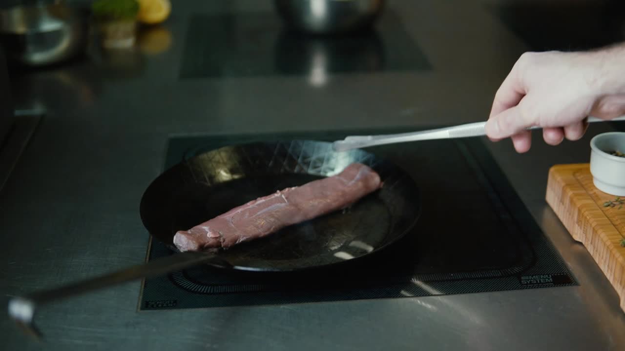 Sizzling Delights: Masterful Chef putting Mouthwatering Meat Dish From A Deer in a pan to roast it