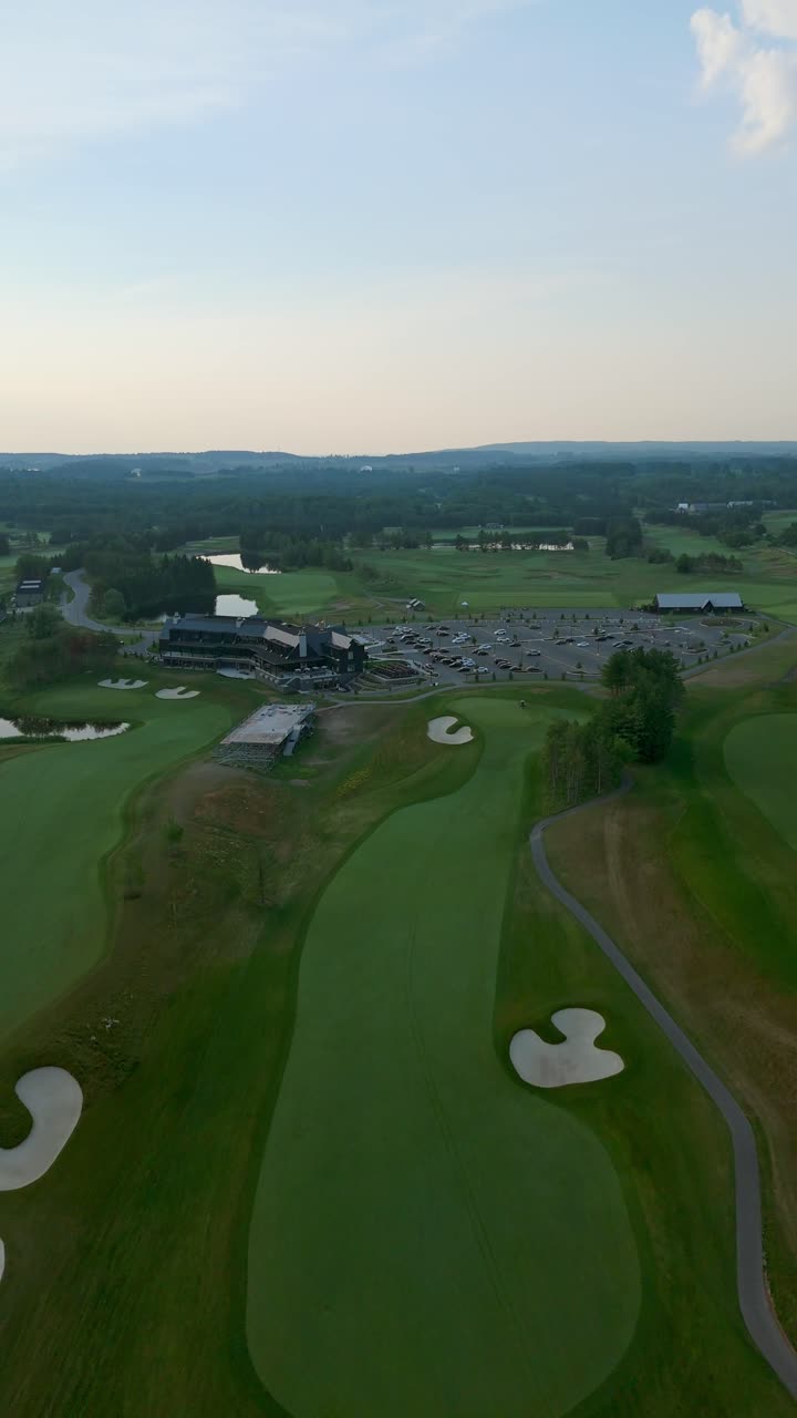 Vertical drone shot showing Osprey Valley golf course with clubhouse, parking, greenery and ponds