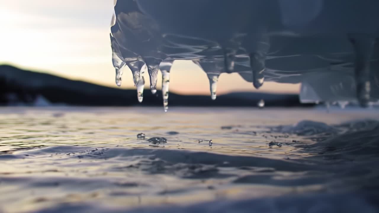 Water droplets fall gracefully from the underside of a boat as the sun sets over a tranquil lake. The gentle ripples reflect the warm colors of the horizon, creating a peaceful atmosphere.