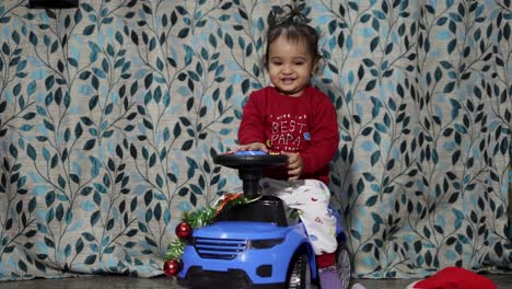 cute infant enjoying christmas eve celebration with kid car gift at home at night