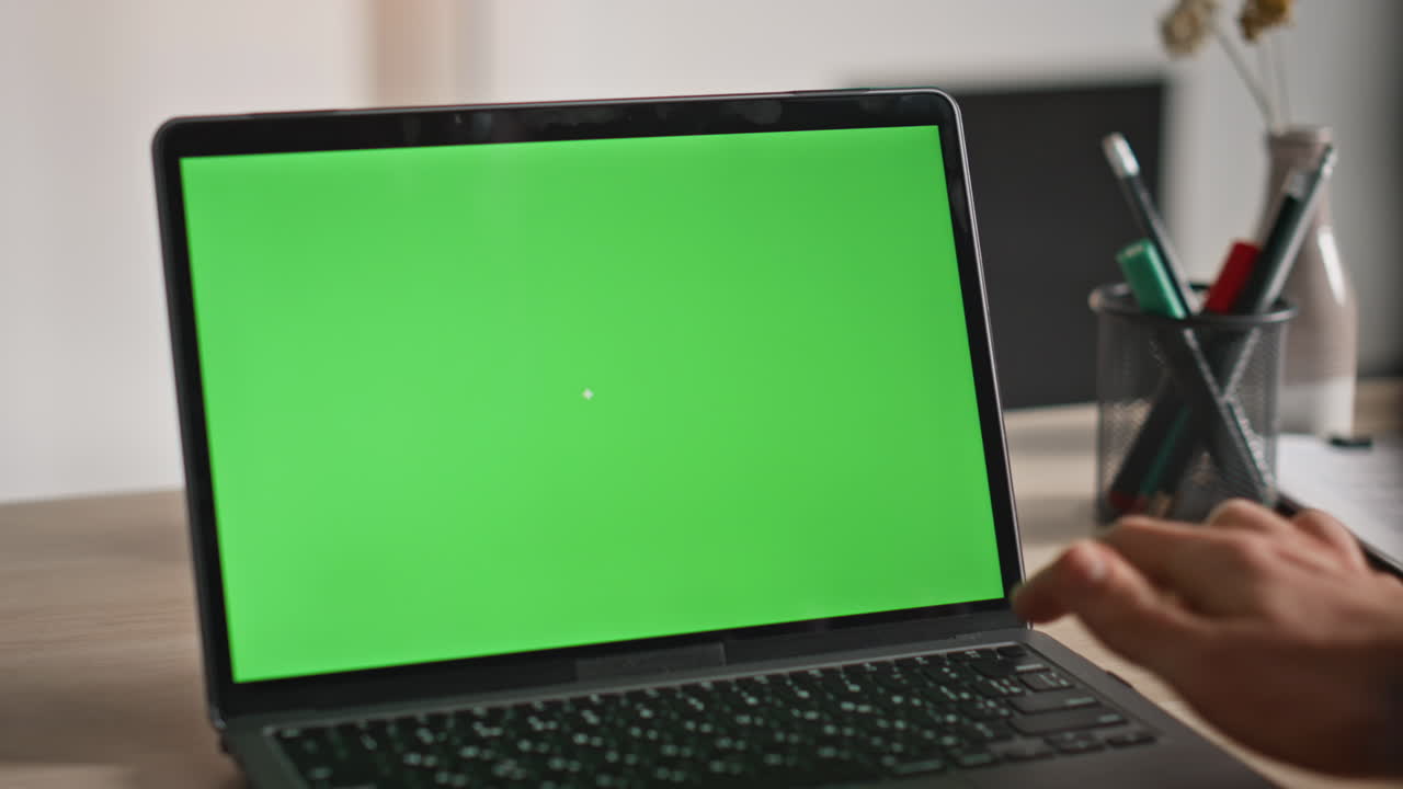 Employee watching green screen laptop at workplace closeup. Hands pressing key
