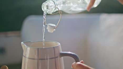 girl hands pouring aqua at jug at fresh air place closeup. woman drinking water