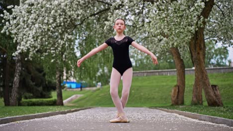 young ballerina posing in a park