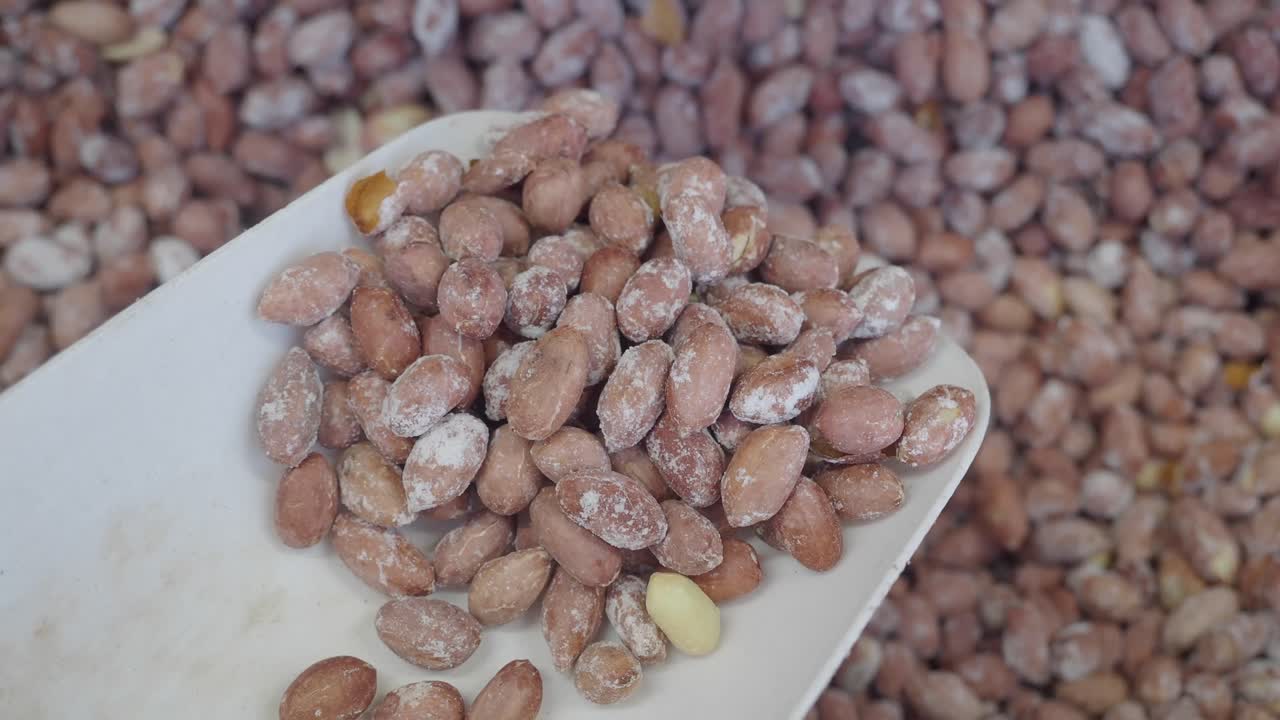 Raw Peanuts in a White Scoop