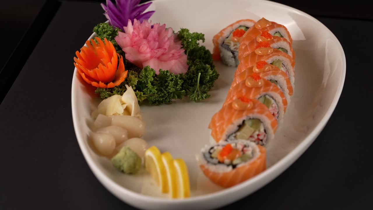 A stunning presentation of fresh salmon sushi rolls, elegantly finished with vibrant fish roe. 신선한 연어 스시 롤 위에 톡톡 터지는 날치알이 더해진 정갈한 한 접시.