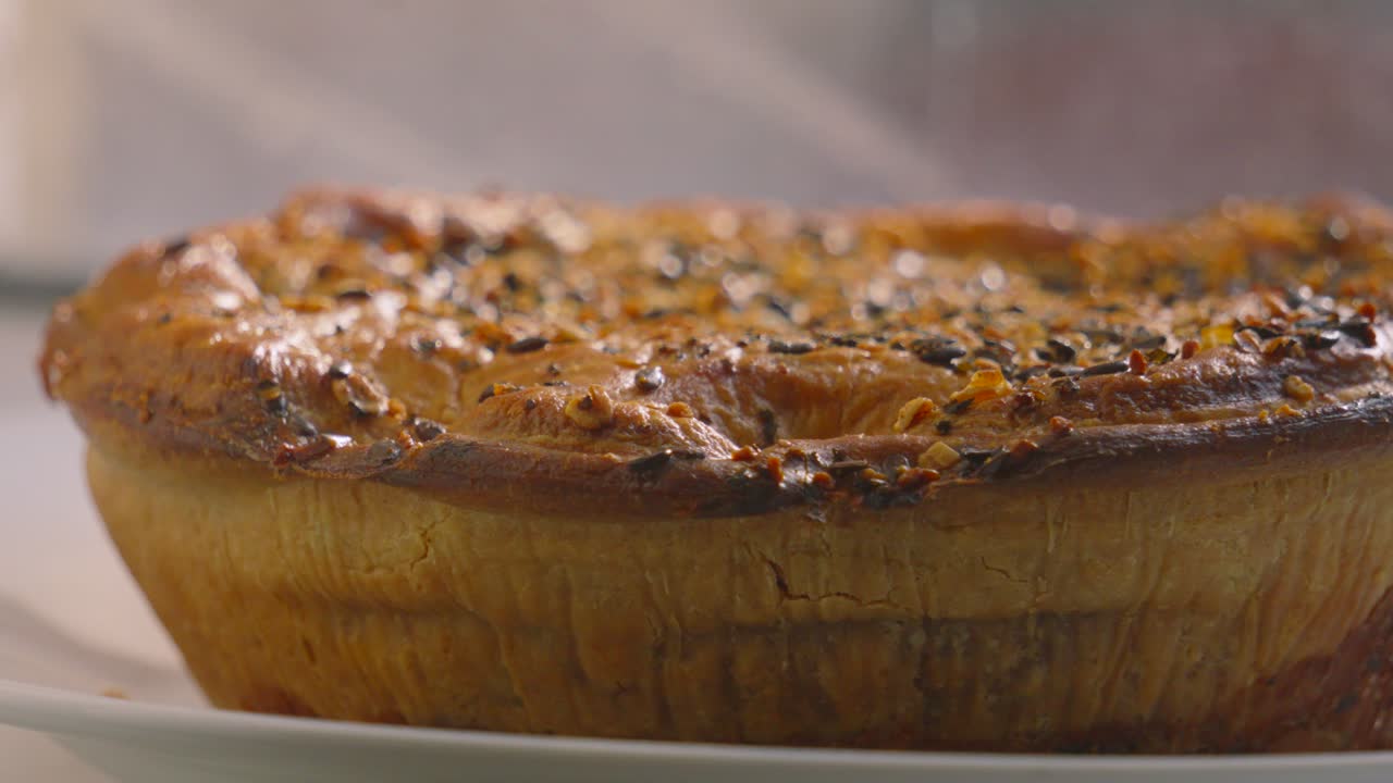 Panning View to Gourmet Chicken and Mushroom Pie on Windowsill with Seeds on Top with Rustic Texture of Pastry Ready to Portion and Serve for Dinner. British Food Cuisine