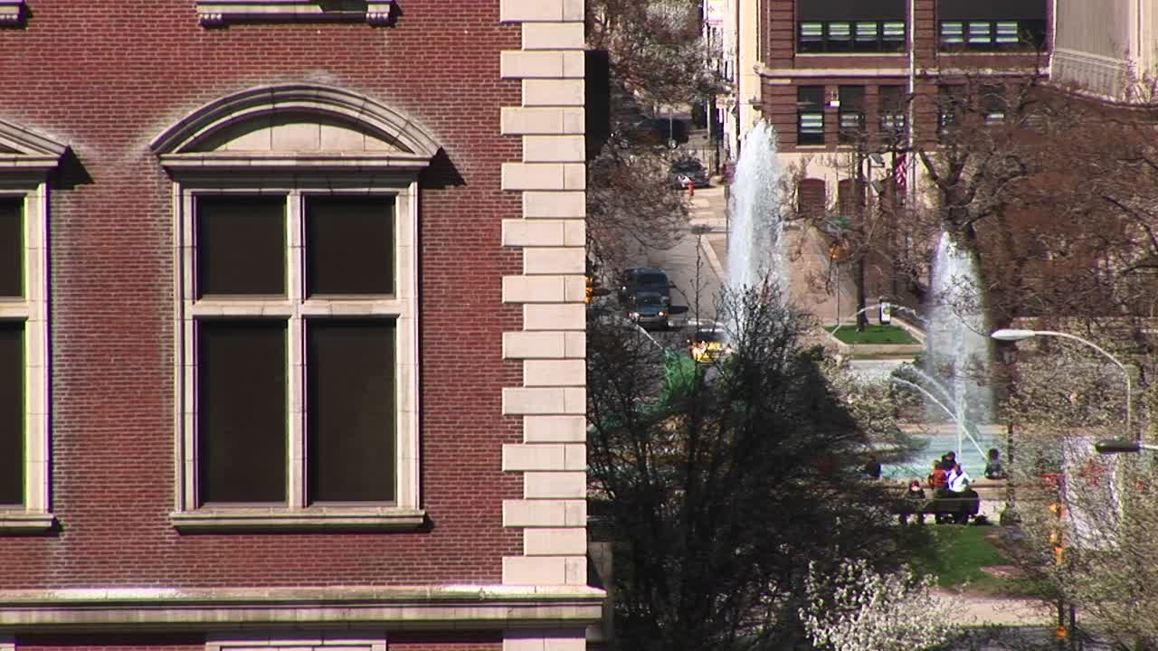 전경에 고전적인 오래된 건물 코너가 있는 분수가 있는 시내 공원의 모습