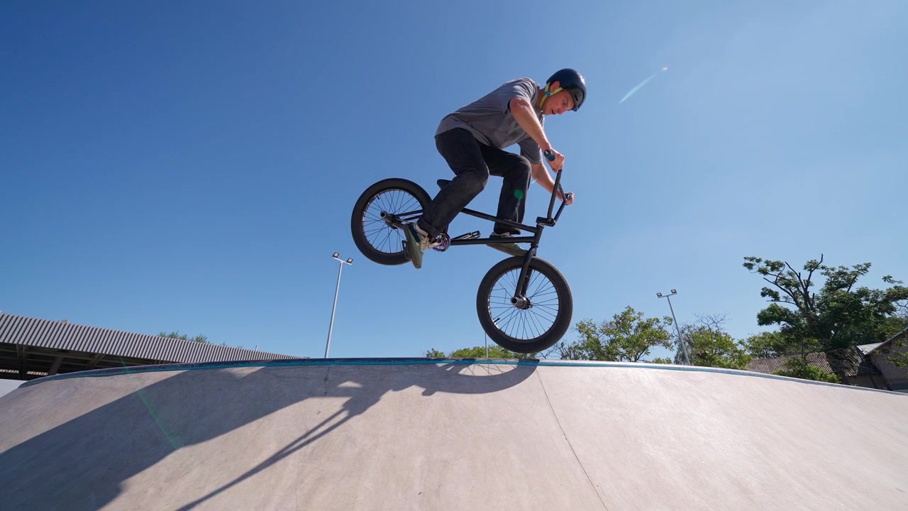 Ciclista BMX che salta su una rampa in uno skatepark