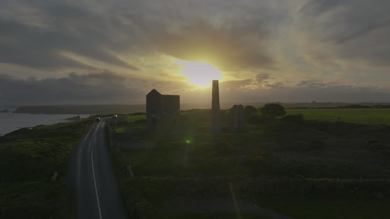 Tankardstown Copper Mine, County Waterford, Ireland, April 2025. Drone circles counterclockwise, Irish historical building at golden hour skies, ocean cliffs and winding road