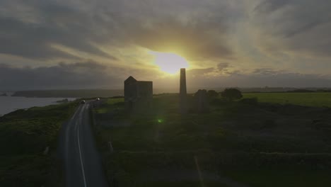 tankardstown copper mine, county waterford, ireland, april 2025. drone circles counterclockwise, irish historical building at golden hour skies, ocean cliffs and winding road