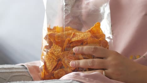 woman holding a bag of tortilla chips