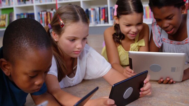 School kids and teacher using digital tablet in library