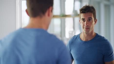 man checking his appearance in the mirror