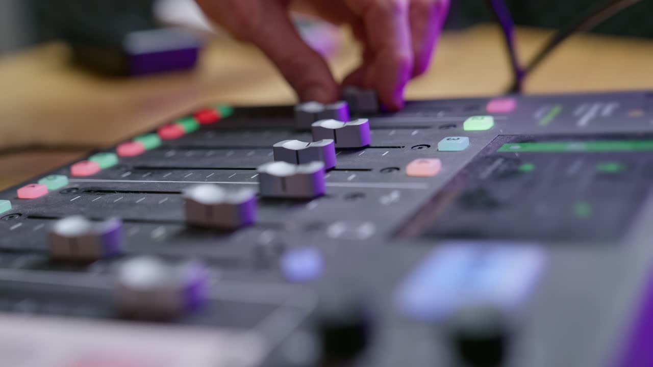 Sound engineer's hands adjusting sliders on an audio console. Professional studio, audio mixing, sound control, precision, and workflow. Perfect for music production, podcasting, or broadcasting