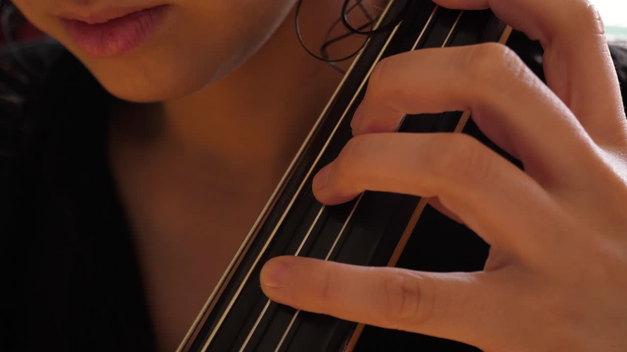 Close-Up of Musician's Hands Playing a String Instrument