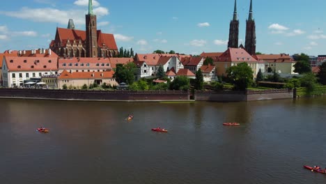 wrocław cinematic drone video of kayakers on odra river next to cathedral island