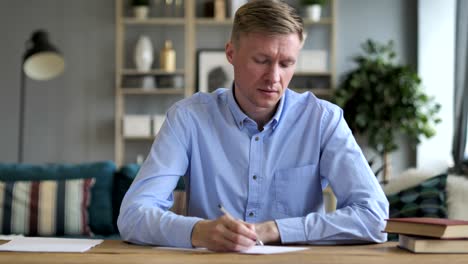 pensive businessman writing while sitting in office, writer