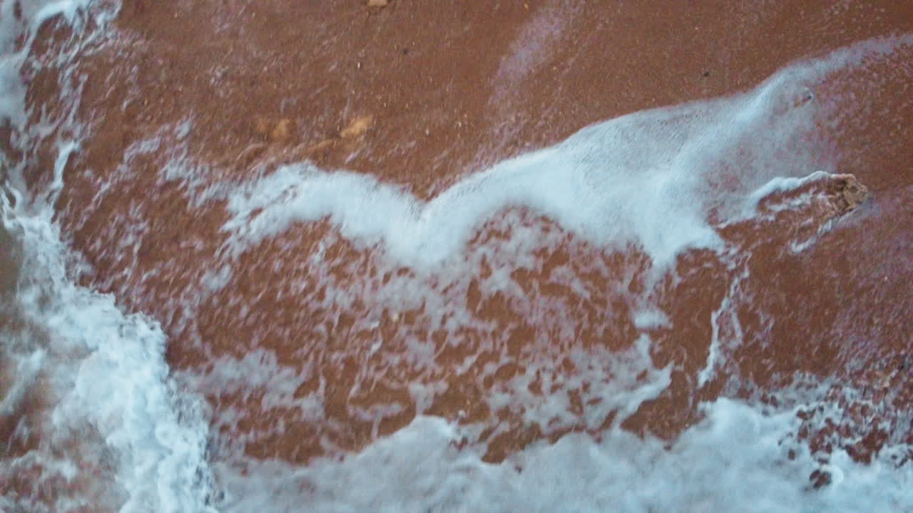 Drift above Portugal's beach, where waves dance and a drone unveils the rocky shore&mdash;nature's rhythm and coastal beauty captured from a captivating aerial perspective