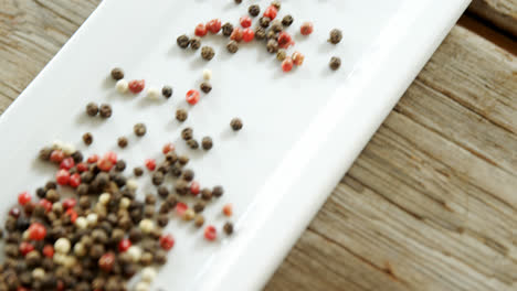 black pepper in tray on wooden plank 4k