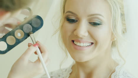 attractive blonde bride doing makeup 1