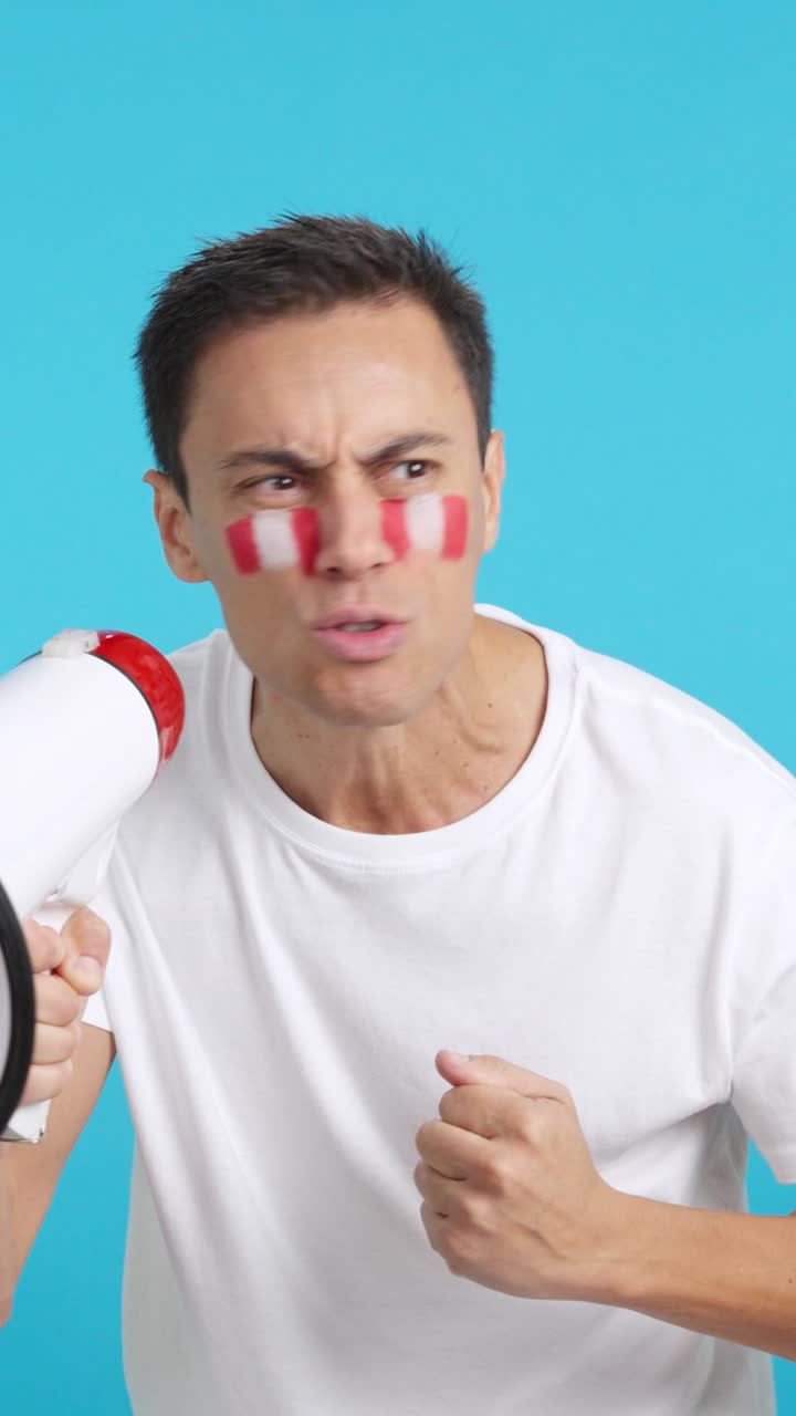 Excited man with peruvian flag on face using a megaphone
