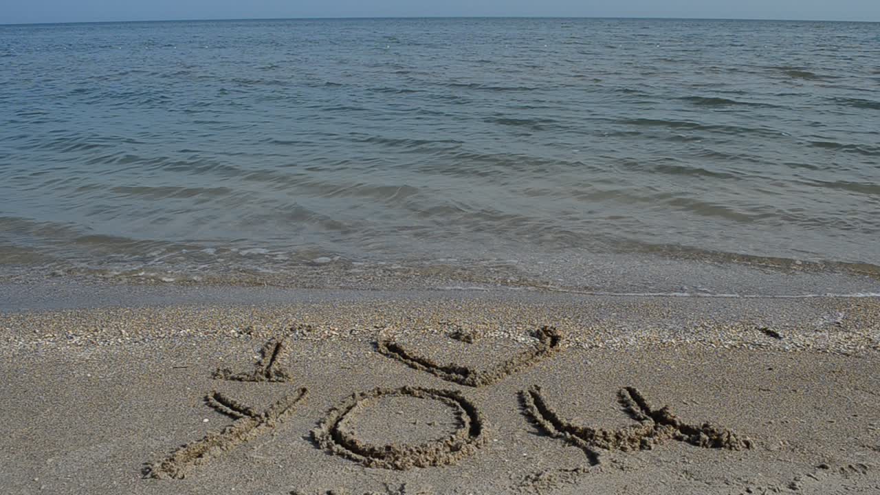 Inscription on the beach. Shooting on the beach. Shooting on the beach