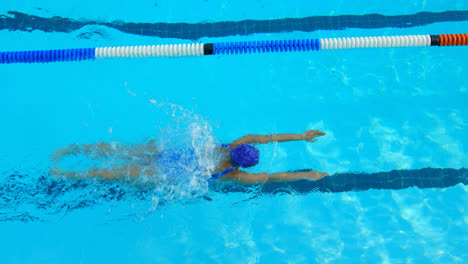 High-angle-view-of-young-female-swimmer-swimming-inside-pool-4k